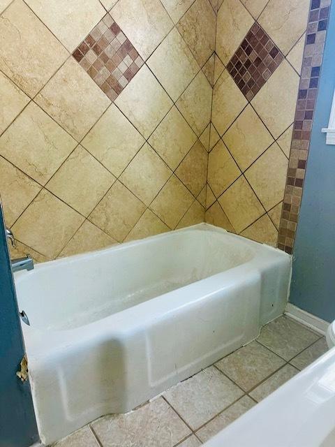 bathroom featuring tile patterned flooring and a bathtub