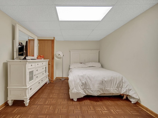 bedroom with a paneled ceiling and light parquet flooring