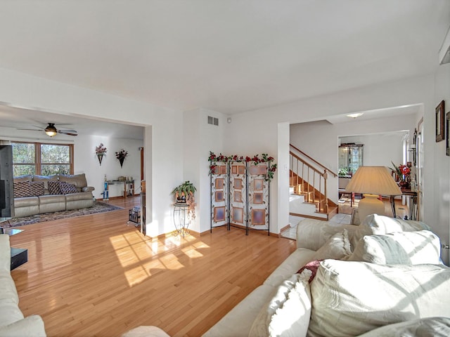 living room featuring ceiling fan and light hardwood / wood-style flooring