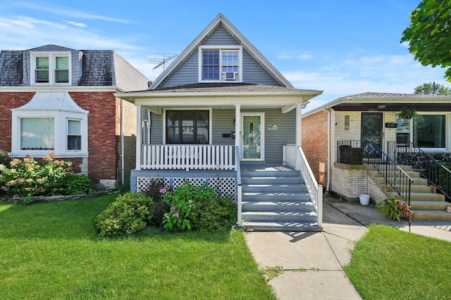 bungalow featuring a porch and a front lawn