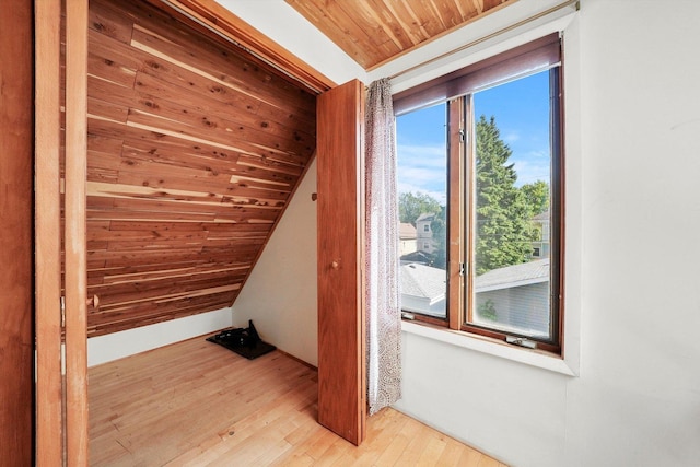 bonus room with vaulted ceiling, a wealth of natural light, wood ceiling, and light hardwood / wood-style flooring