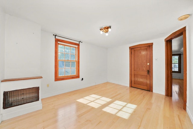 unfurnished living room featuring light wood-type flooring and a healthy amount of sunlight