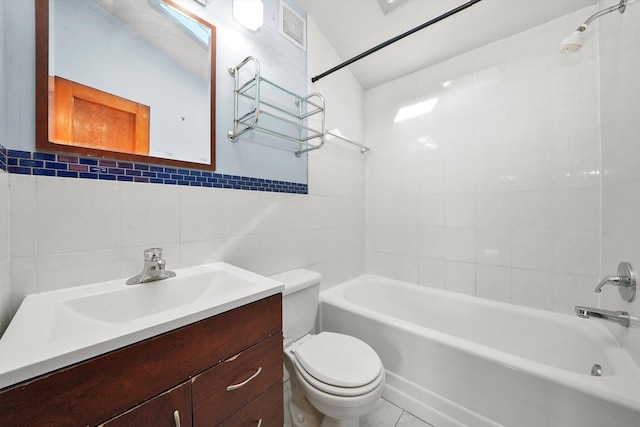 full bathroom featuring tiled shower / bath, tile walls, toilet, tile patterned floors, and vanity