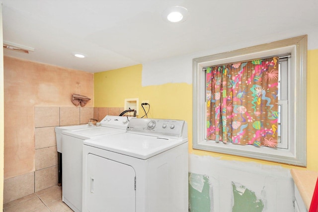 washroom with separate washer and dryer, tile walls, and light tile patterned flooring