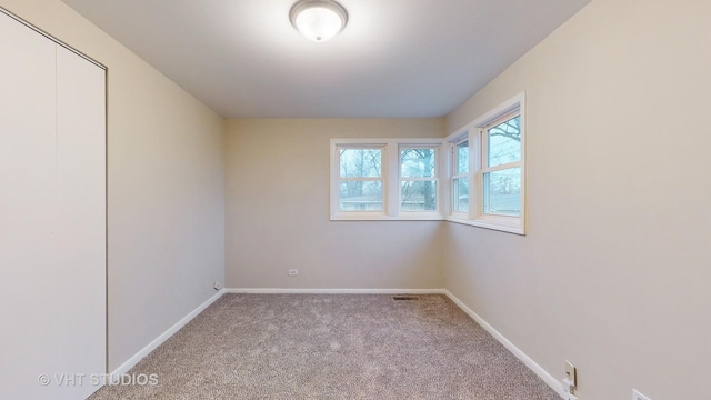 unfurnished room featuring light carpet