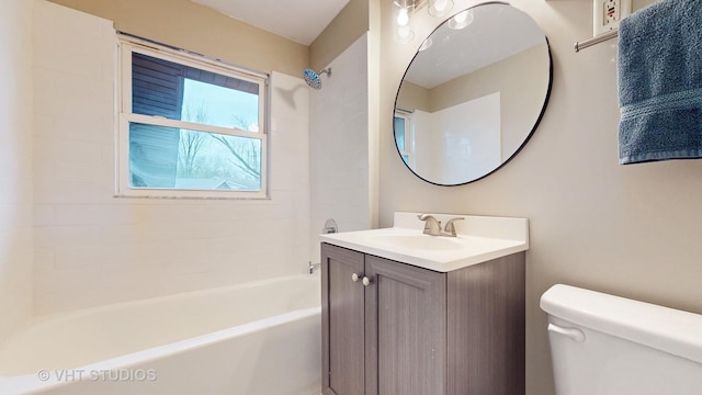 full bathroom featuring tiled shower / bath, vanity, and toilet