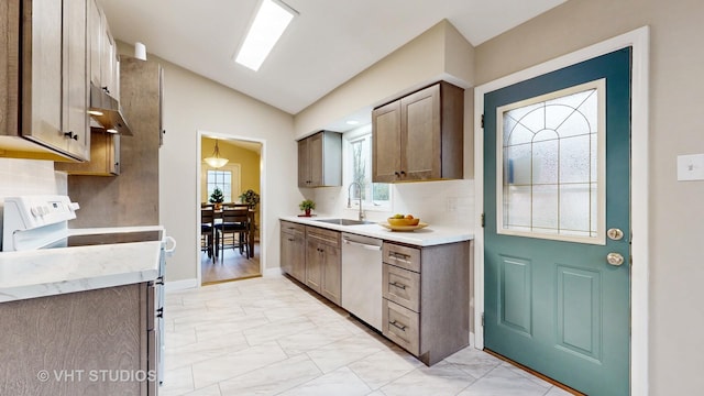 kitchen featuring lofted ceiling, sink, tasteful backsplash, and dishwasher