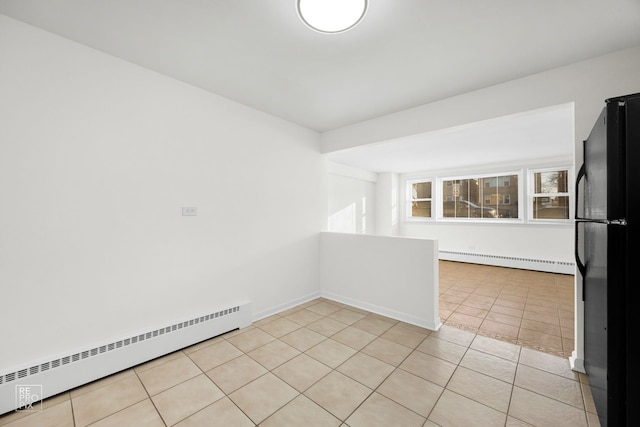 tiled empty room with a baseboard radiator