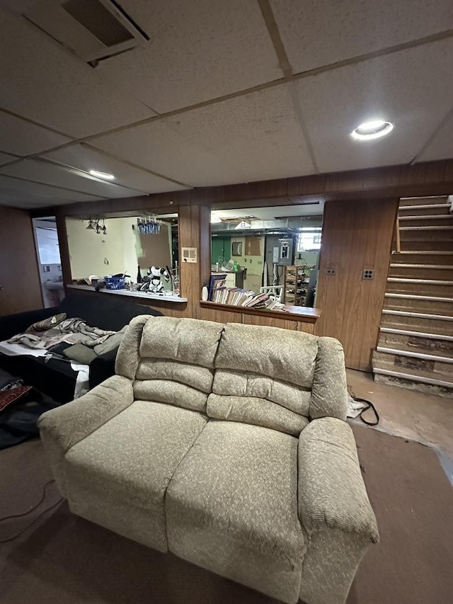 living room featuring concrete floors, wood walls, and bar area