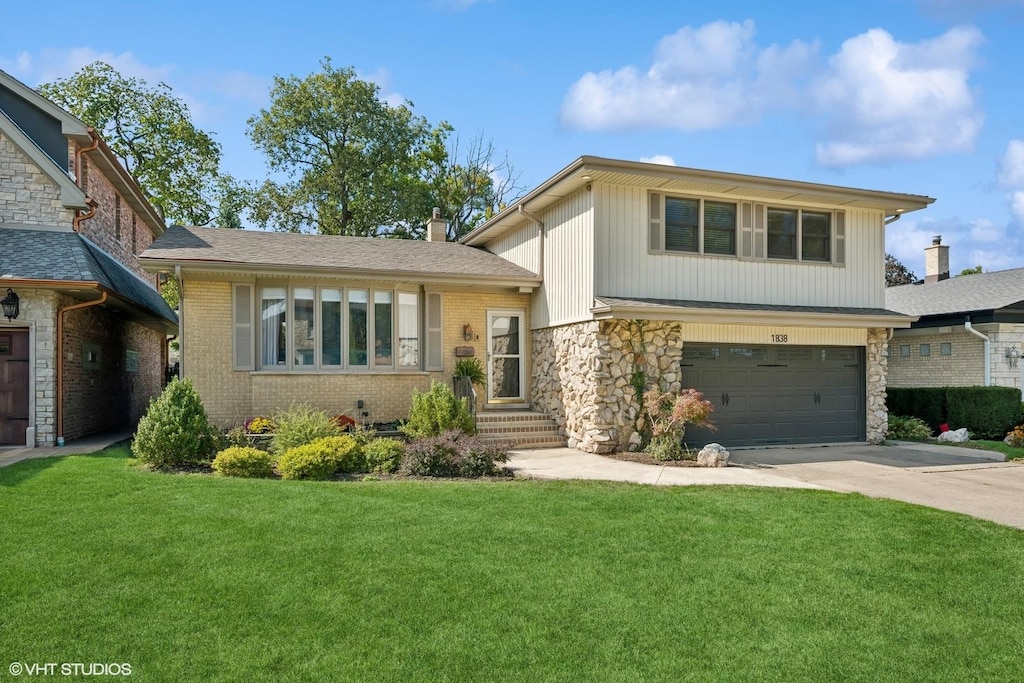 split level home featuring a front lawn and a garage