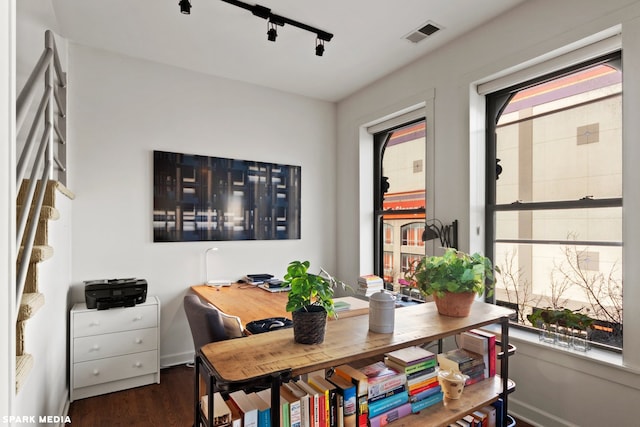 home office with rail lighting and dark hardwood / wood-style floors