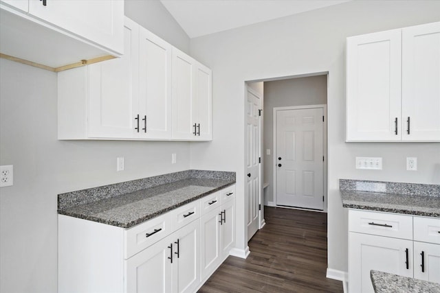 kitchen featuring dark stone countertops and white cabinets