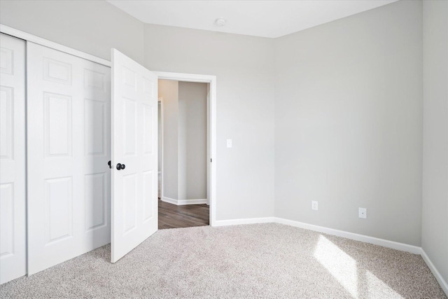 unfurnished bedroom featuring dark carpet and a closet