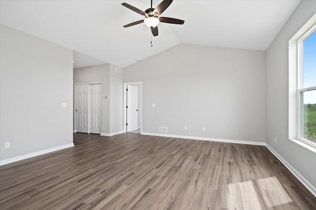 unfurnished living room featuring dark hardwood / wood-style flooring, vaulted ceiling, and ceiling fan