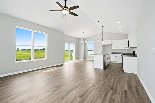 kitchen with pendant lighting, appliances with stainless steel finishes, a center island, white cabinets, and ceiling fan with notable chandelier