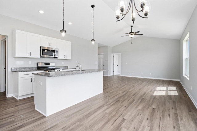 kitchen with appliances with stainless steel finishes, sink, an island with sink, and white cabinets