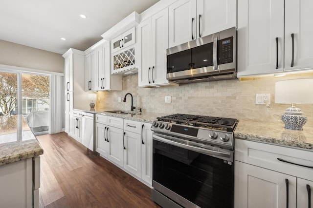 kitchen featuring white cabinetry, stainless steel appliances, sink, backsplash, and dark hardwood / wood-style floors