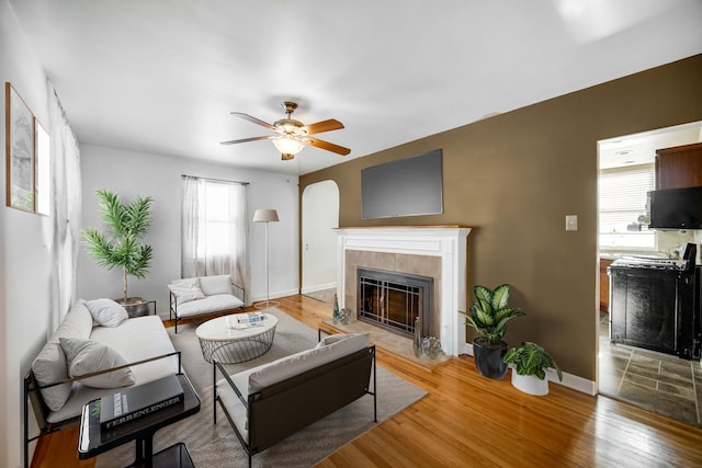 living room featuring hardwood / wood-style floors, a fireplace, ceiling fan, and plenty of natural light