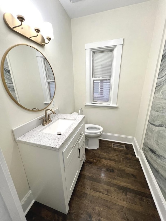 bathroom with toilet, wood-type flooring, and vanity