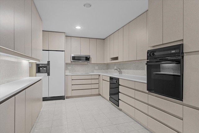 kitchen featuring black appliances, backsplash, sink, and light tile patterned floors