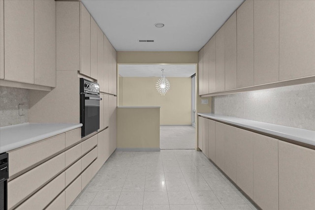 kitchen with an inviting chandelier, black appliances, and hanging light fixtures