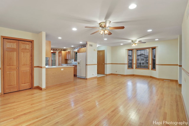 unfurnished living room featuring light hardwood / wood-style floors and ceiling fan