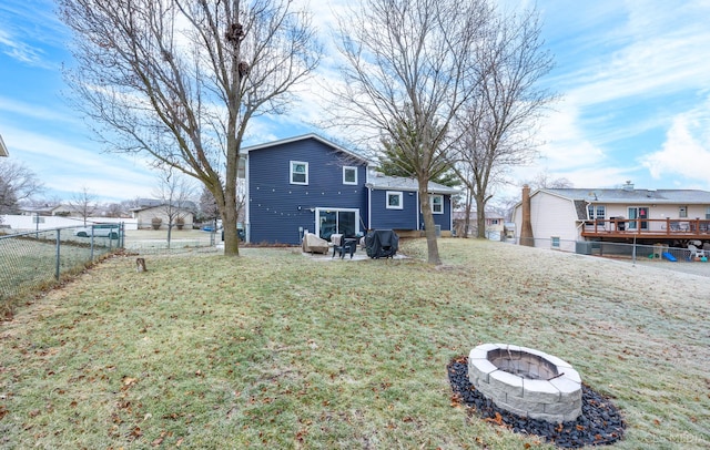 exterior space featuring an outdoor fire pit, a yard, a patio area, and a wooden deck