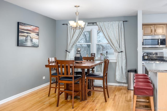 dining room with a notable chandelier and light wood-type flooring