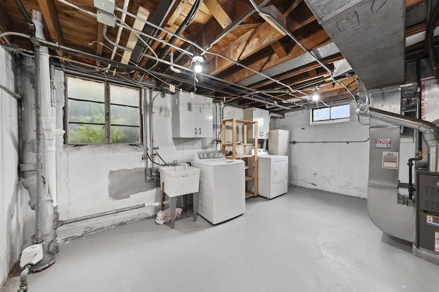 basement with washer and dryer, sink, and heating unit