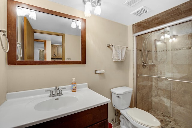 bathroom with vanity, a shower with shower door, and toilet