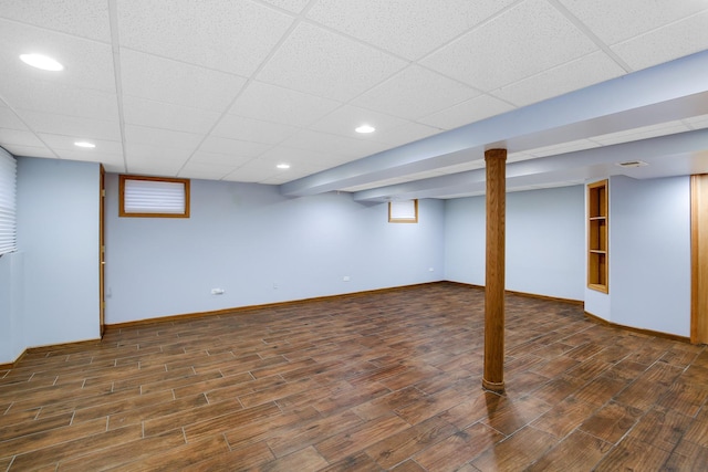 basement with dark hardwood / wood-style floors and a paneled ceiling