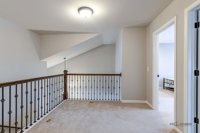 hall featuring light colored carpet and vaulted ceiling