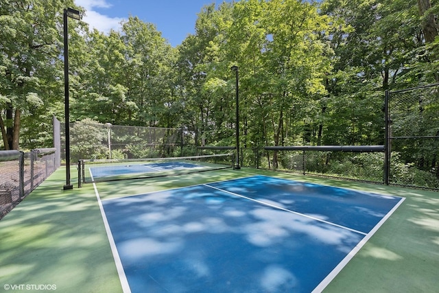 view of tennis court featuring fence