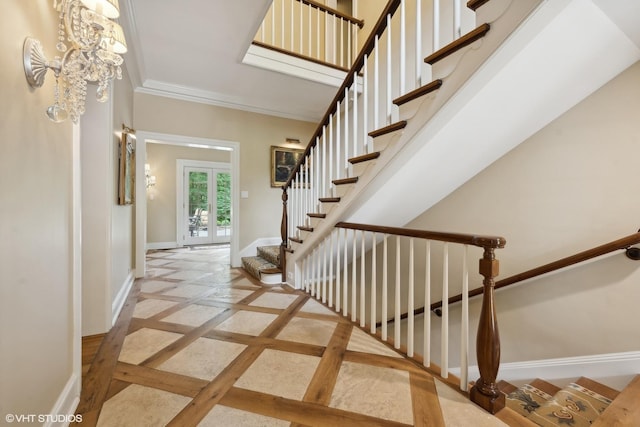 stairs featuring a notable chandelier, french doors, and crown molding