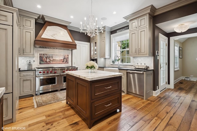 kitchen with baseboards, light wood-style flooring, custom range hood, dark stone countertops, and stainless steel appliances