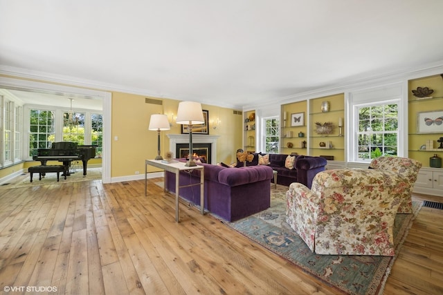 living room featuring a warm lit fireplace, crown molding, baseboards, and hardwood / wood-style floors