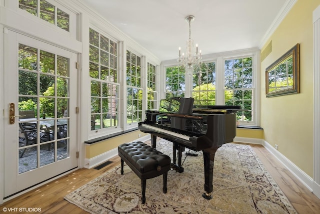 living area with visible vents, crown molding, baseboards, and wood finished floors