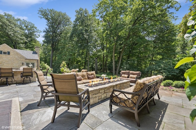 view of patio with an outdoor living space with a fire pit