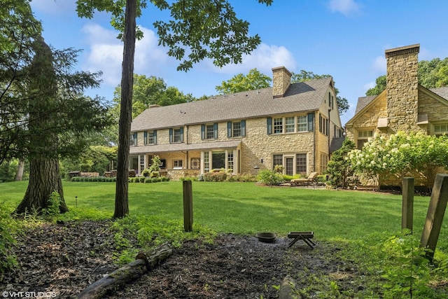 view of front of property with a chimney and a front lawn