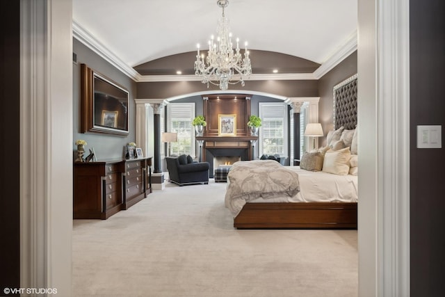 carpeted bedroom with ornamental molding, vaulted ceiling, a lit fireplace, and ornate columns