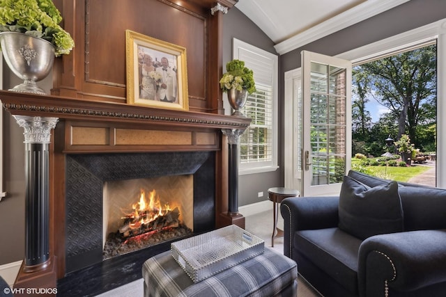 sitting room with ornamental molding, a tile fireplace, and lofted ceiling