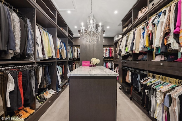 walk in closet with light colored carpet and an inviting chandelier