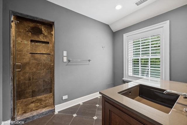 bathroom featuring a stall shower, visible vents, tile patterned flooring, vaulted ceiling, and a sink