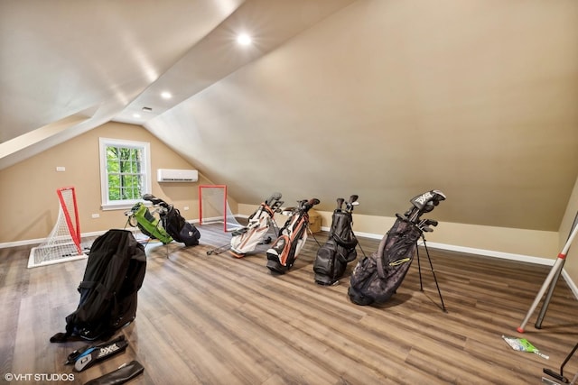 interior space with baseboards, a wall unit AC, wood finished floors, vaulted ceiling, and recessed lighting