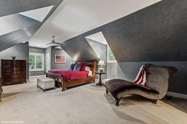 bedroom with ceiling fan, light colored carpet, and vaulted ceiling