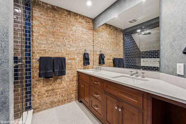 bathroom with double vanity, visible vents, a sink, and tiled shower