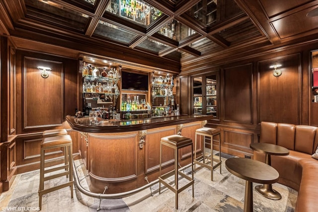 bar with wood walls, coffered ceiling, wet bar, beamed ceiling, and crown molding