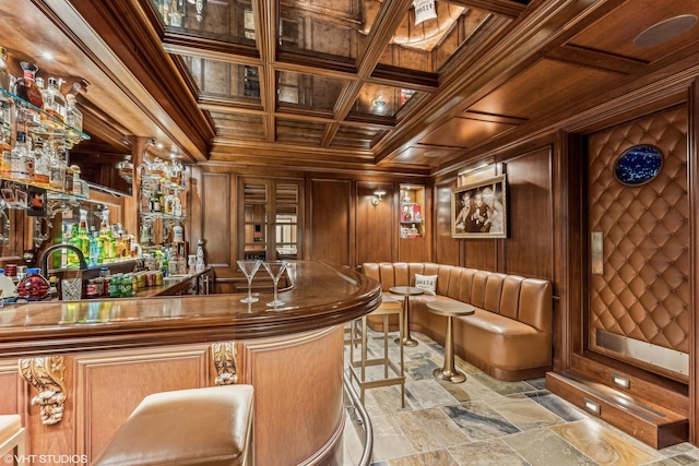 bar featuring wooden walls, beamed ceiling, ornamental molding, coffered ceiling, and wood ceiling