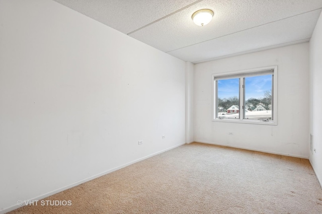 unfurnished room with carpet floors and a textured ceiling