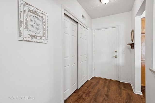 entryway with dark hardwood / wood-style floors and a textured ceiling